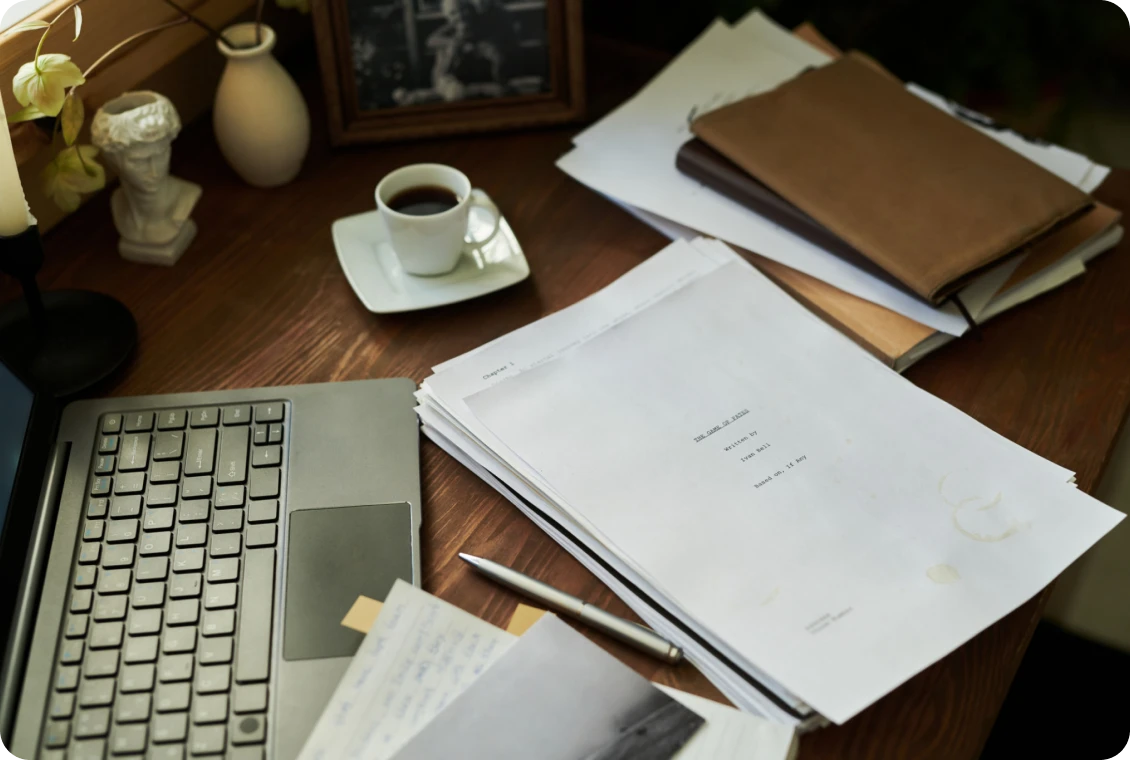 Laptop and documents on wooden desk.